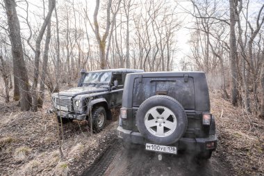 Finlandiya Körfezi. Leningrad bölgesi, Rusya, 14 Nisan 2019: bir orman yolunda jeep Wrangler ve land Rover savunucusu. Wrangler yolda ve spor yeni araç kapalı kompakt bir dört tekerlekten çekiş