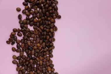 Pembe arka planda kahve çekirdekleri ve boş alan.