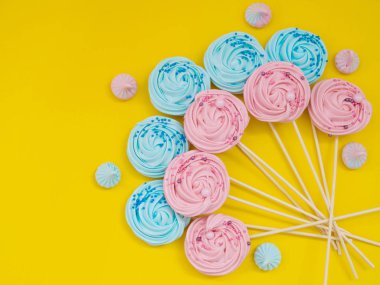 beze. Bright meringues sarı bir arka plan üzerinde renkli.