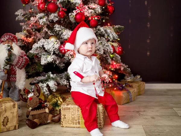 Bir hediye ile Noel ağacı yakınındaki küçük Noel baba bebek — Stok fotoğraf