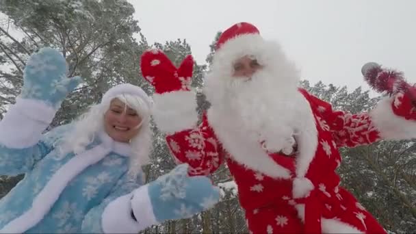 Санта Клаус и внучка машут руками на камеру в лесу. Ускоренное видео — стоковое видео