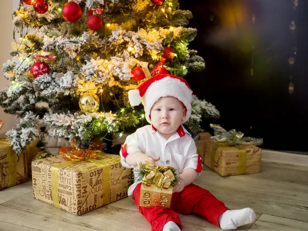 Noel ağacı yakınındaki bir yay ile altın bir kutu ile küçük şirin bebek — Stok fotoğraf
