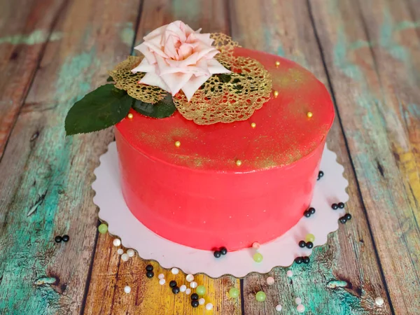 Beautiful red cake with a rose on a wooden painted table — Stock Photo, Image