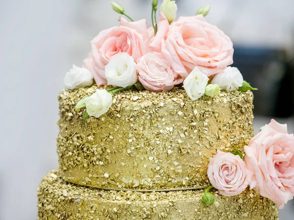 Piękny tort weselny z golden trzypiętrowy ozdobiony kwiatami — Zdjęcie stockowe