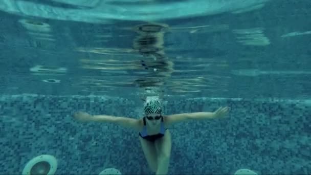 Дівчина плаває в басейні під водою — стокове відео