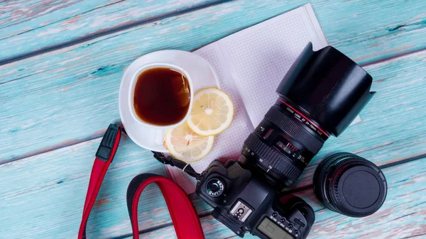 Professional digital camera with long-focus lens on a wooden background — Stock Photo, Image