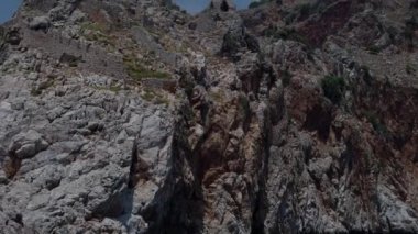 Kabartma deniz seviyesinden koyu kahverengi kayalıklarla. Türkiye