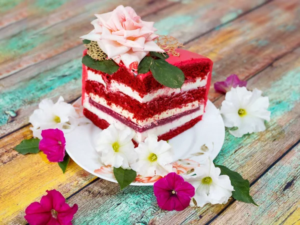 A piece of festive red cake on a wooden background — Stock Photo, Image