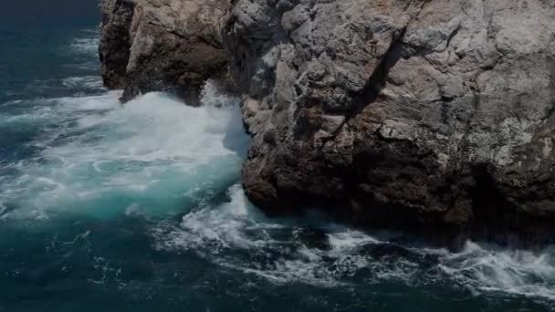 Starke Welle prallt an einem Sommertag auf einen Felsen. — Stockvideo