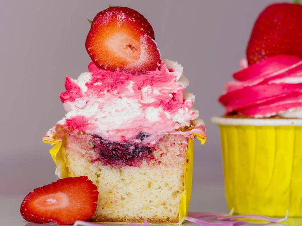 Cupcakes com morangos frescos em uma redução em um fundo rosa close-up — Fotografia de Stock