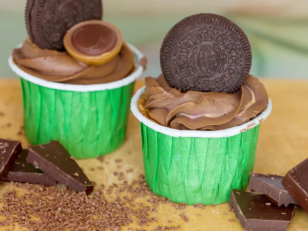 Deliciosos cupcakes de chocolate em uma placa de madeira — Fotografia de Stock