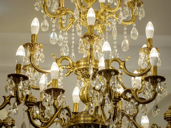 Hermosa lámpara de araña de oro con velas de primer plano colgando en el techo — Foto de Stock