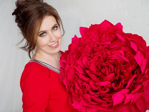 Retrato de una hermosa chica con una flor artificial roja — Foto de Stock