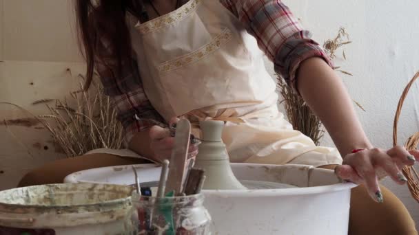 Mujer Potter esculpe producto de arcilla en una rueda de alfarero — Vídeos de Stock