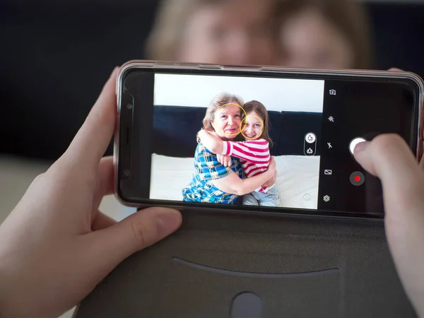 Abuela y nieta en la pantalla del teléfono. Fotos en el teléfono — Foto de Stock