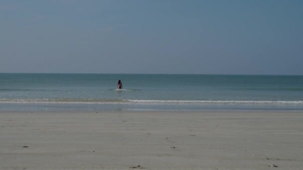 一个穿着游泳衣的女孩高兴地走进大海。4k — 图库视频影像