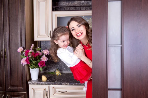 Happy family laughing merrily peeking out of the kitchen door