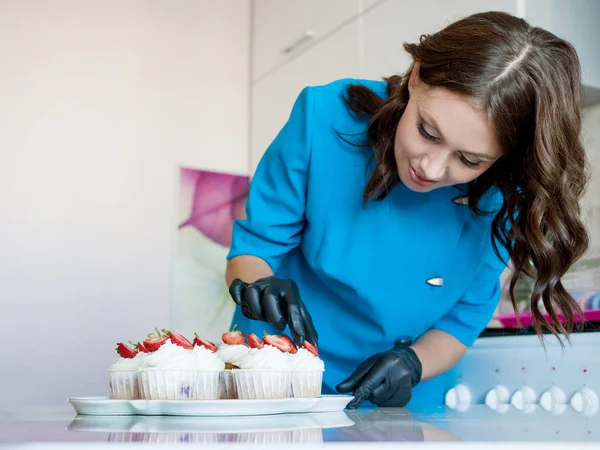 Chef fille décore dessert avec des tranches de fraise dans la cuisine — Photo