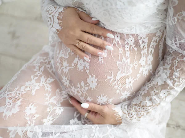 Mujeres manos en el vientre de una mujer embarazada — Foto de Stock