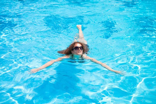Uma jovem nada em uma piscina em um resort — Fotografia de Stock