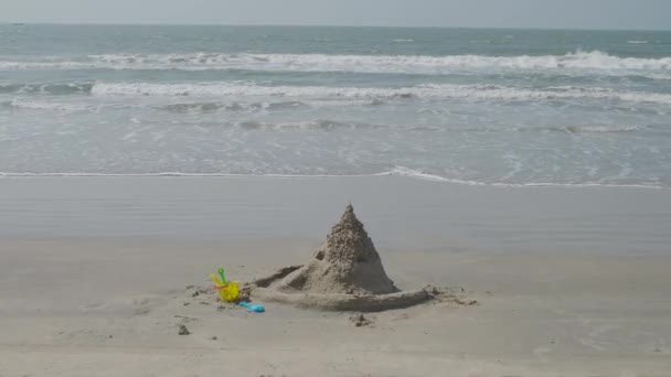 Песчаный замок, ведро и лопата у моря — стоковое видео