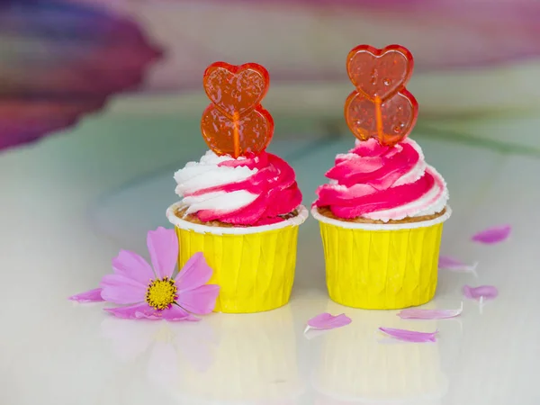 Dois cupcakes de framboesa com creme rosa na mesa — Fotografia de Stock