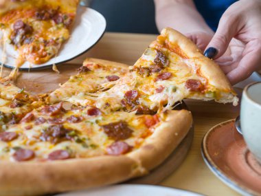 Iştah açıcı pizza yakın ve bir dilim pizza ile eller