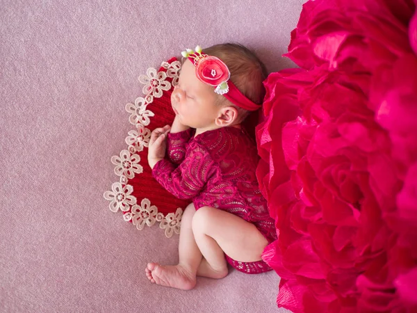 Beautiful newborn baby in red fashionable clothes. — Stock Photo, Image