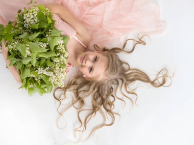 Beyaz leylak bir buket ile güzel kız sırtında yatıyor