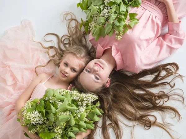 Portrait of two beautiful girls with lilac — Stock Photo, Image
