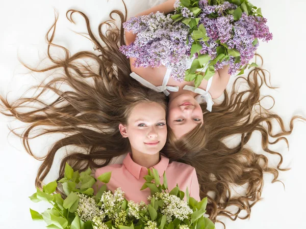 Ragazze con i capelli lunghi e lilla nelle loro mani — Foto Stock