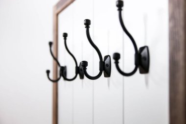 Beyaz duvarı tutan siyah askı