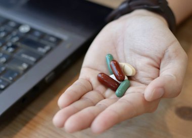 Klavye geçmişi ve sağlık hizmetleri konsepti olan hapların görüntüsünü kapat.