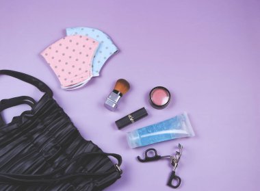 Pembe ve mavi benekli yüz maskesi ve dezenfektan jeli kadın el çantası aksesuarları, COVID-19 'dan korunma ve yeni normal yaşam tarzı kavramı..