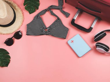 Seyahat ve yaz tatili konsepti, siyah beyaz çizgili bikini mayo, pasaport ve kadın tatil aksesuarları pembe arka planda tropikal canavar yapraklı..