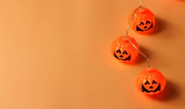 Cadılar Bayramı balkabağı ışıklarının turuncu arka planda fotokopi alanı ile üst görüntüsü. Cadılar Bayramı konsepti.