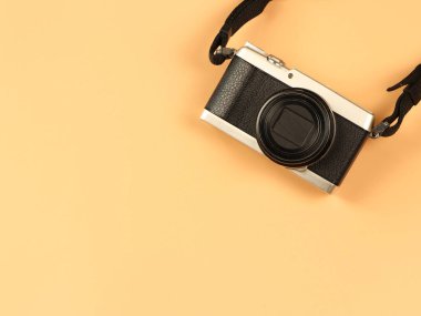Turuncu zemin üzerinde fotokopi alanı olan klasik kameranın üst görüntüsü ya da düzlüğü. Serbest, yaratıcı, hobi konsepti.