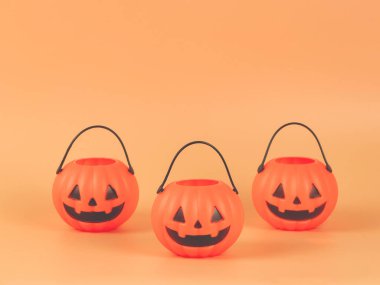 Turuncu arka planda üç Cadılar Bayramı balkabağı kovası ve fotokopi alanı. Cadılar Bayramı konsepti.