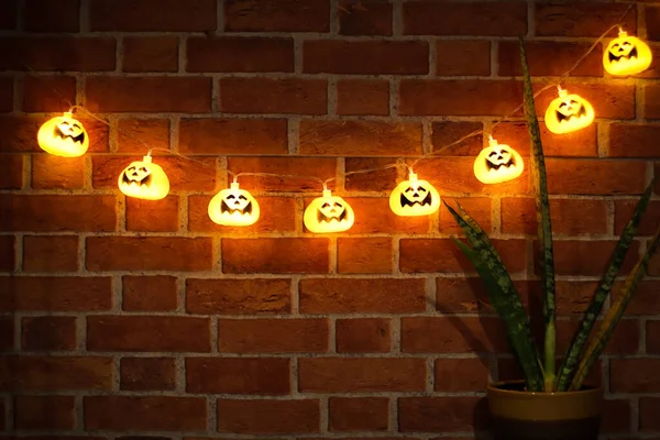 Imagem Escura Luzes Corda Abóbora Halloween Brilhando Pendurado Parede Tijolo — Fotografia de Stock