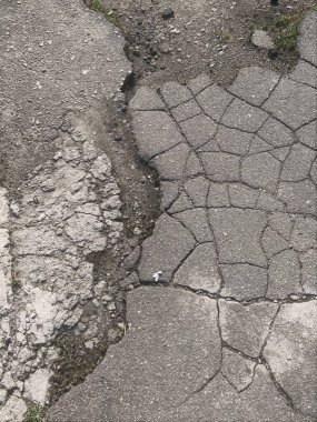 Yerdeki arka plan deseni eski gururlu yol birçok asfalt ve beton parçasına kayıyor.