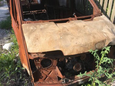 Evin arka bahçesinde paslı bir araba cesedi var..