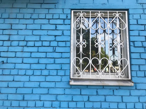 蓝色砖墙后面的白色窗户 — 图库照片