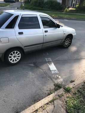 Gümüş renkli araba şehrin caddesi boyunca gidiyor..