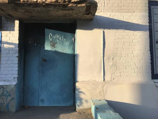 Παλιές Μπλε Μεταλλικές Πόρτες Και Ένα Λευκό Τοίχο Από Τούβλα — Φωτογραφία Αρχείου