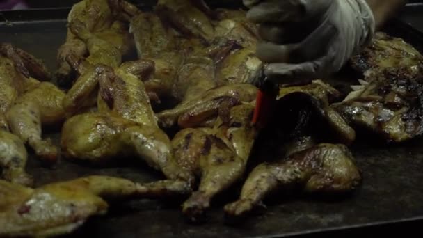 Street food cook grillar grillade kycklingar och strippar dem med en spatel — Stockvideo
