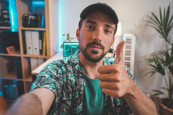 За сценой снят молодой человек, влияющий на создание видео. Очень красивый мужчина с бородой снимает видео для соцсетей, разговаривающих непосредственно с камерой. Удивительное рабочее пространство Влиятеля.