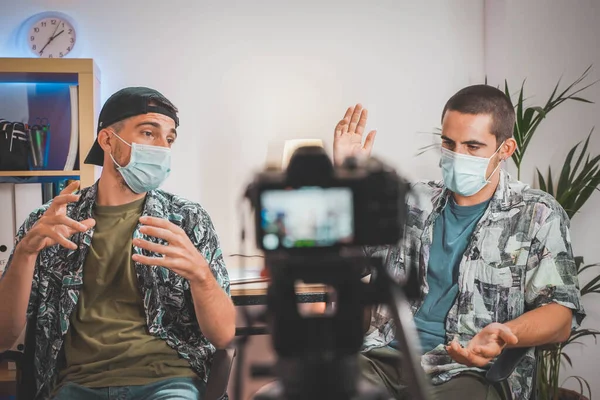 Influencers with face mask making an interview with video camera. Influencers making online video. Amazing work space. Working in video.