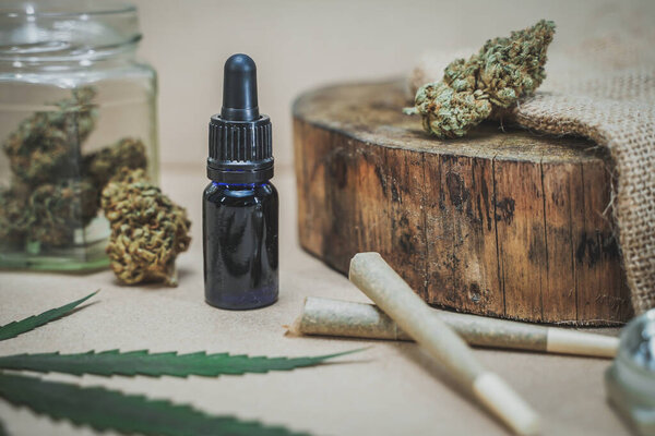 Стеклянная бутылка с CBD масла и конопли листья на деревянном фоне. Органические и натуральные косметические средства на основе конопли и косметики. Медицинская концепция конопли. Натюрморт Расслабляющий ладан.