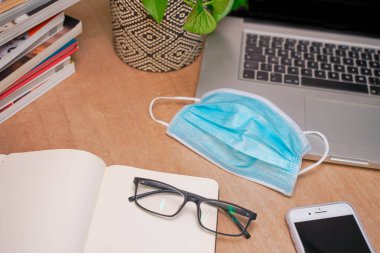 Bilgisayarı ve akıllı telefonu olan güzel bir çalışma alanı. Küçük bir şirket çalışıyor ve iş yapıyor. Karantina sırasında evde çalışmak. Küçük ofis. Coronavirüs. 
