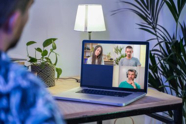 Bir iş adamının iş arkadaşlarıyla video konferans planı hakkında konuştuğu görüntüler. İş ekibi online görüşme için bilgisayarı kullanıyor. Evden çalışan bir grup zeki insan..
